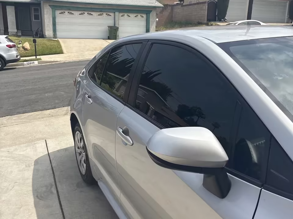 Silver Corolla hatchback with ceramic rear window tint